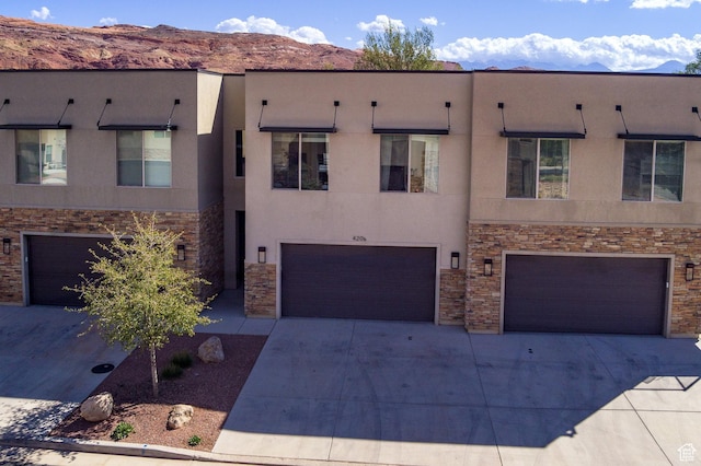 420 N 600 W, Moab, UT 84532 - view of front of house featuring a garage, stucco siding, driveway, and a mountain view