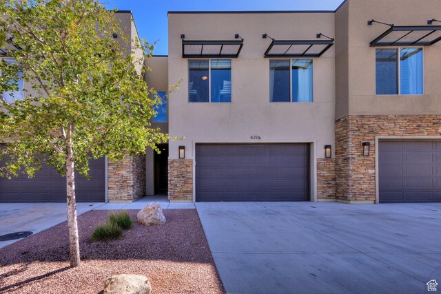420 N 600 W, Moab, UT 84532 - view of front of home with stone siding, stucco siding, an attached garage, and concrete driveway