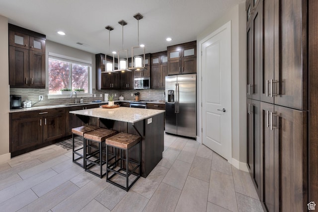 420 N 600 W, Moab, UT 84532 - kitchen featuring appliances with stainless steel finishes, backsplash, dark brown cabinets, a kitchen island, and recessed lighting