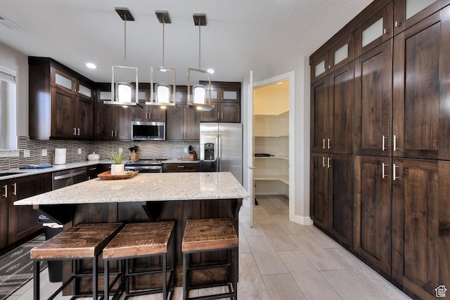 420 N 600 W, Moab, UT 84532 - kitchen featuring stainless steel appliances, dark brown cabinets, tasteful backsplash, a breakfast bar, and recessed lighting