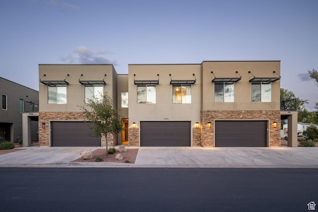 420 N 600 W, Moab, UT 84532 - view of front of house featuring stone siding, a garage, stucco siding, and driveway