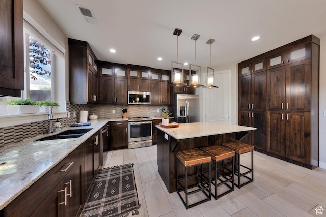 420 N 600 W, Moab, UT 84532 - kitchen with appliances with stainless steel finishes, a sink, a breakfast bar area, decorative backsplash, and recessed lighting