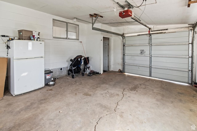 garage featuring a garage door opener and freestanding refrigerator