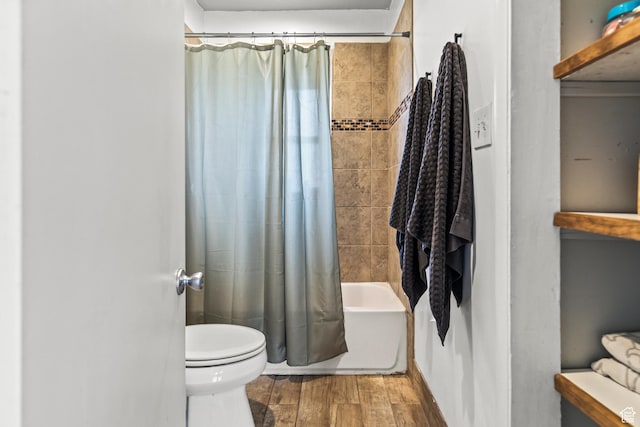 full bath featuring shower / bath combo with shower curtain, toilet, and wood finished floors