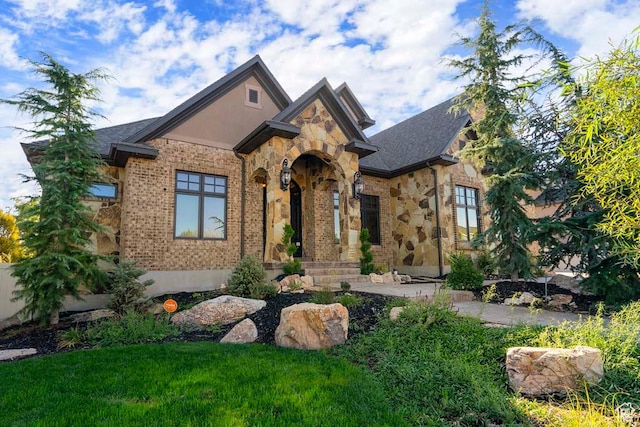 10575 S Alexander Park Ln, South Jordan, UT 84095 - french provincial home with a front yard, stone siding, and brick siding