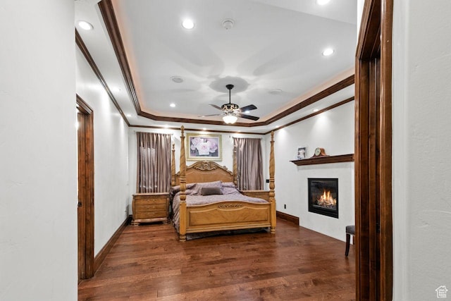 10575 S Alexander Park Ln, South Jordan, UT 84095 - bedroom with a raised ceiling, crown molding, dark wood finished floors, and a glass covered fireplace
