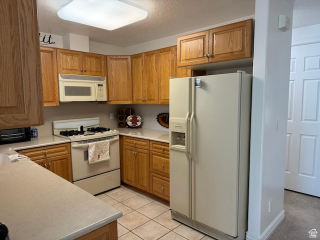 2480 W 450 S Unit 5, Springville, UT 84663 - kitchen featuring light countertops, light tile patterned flooring, brown cabinets, and white appliances