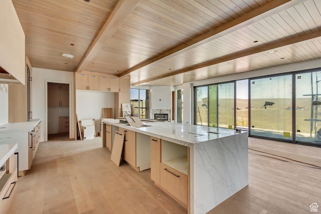7165 Painted Valley Pass Unit 54, Park City, UT 84098 - kitchen featuring a large island, light brown cabinets, modern cabinets, beamed ceiling, and light wood-style floors