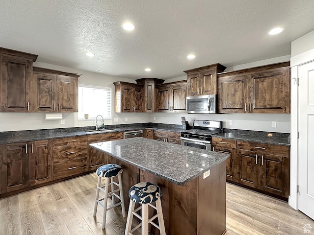 2142 W 3100 S, West Haven, UT 84401 - kitchen with a breakfast bar, light wood-style flooring, stainless steel appliances, and a sink