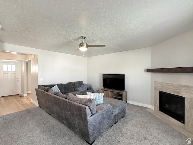 2142 W 3100 S, West Haven, UT 84401 - carpeted living area with a premium fireplace, baseboards, a textured ceiling, a ceiling fan, and wood finished floors