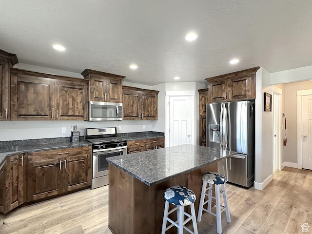 2142 W 3100 S, West Haven, UT 84401 - kitchen with a kitchen bar, stainless steel appliances, recessed lighting, light wood-type flooring, and a center island