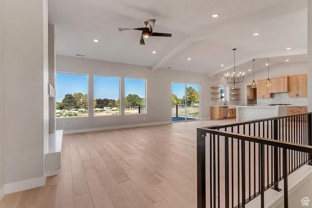 kitchen with ceiling fan with notable chandelier, light brown cabinetry, open floor plan, vaulted ceiling with beams, and decorative backsplash