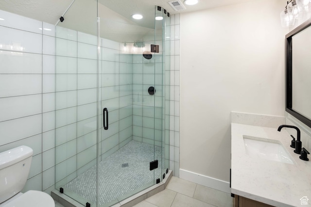 bathroom featuring vanity, a textured ceiling, tile patterned flooring, a shower with door, and toilet