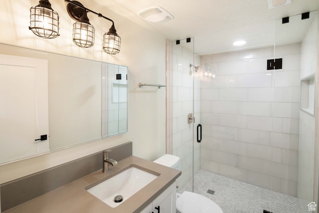 bathroom featuring vanity, toilet, and a shower with door