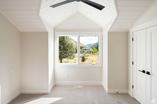 unfurnished bedroom featuring light carpet, vaulted ceiling, ceiling fan, and wooden ceiling