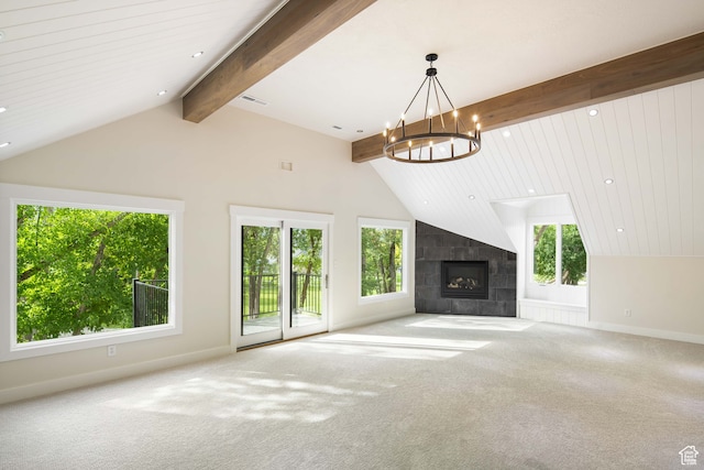 unfurnished living room featuring a notable chandelier, a fireplace, and plenty of natural light