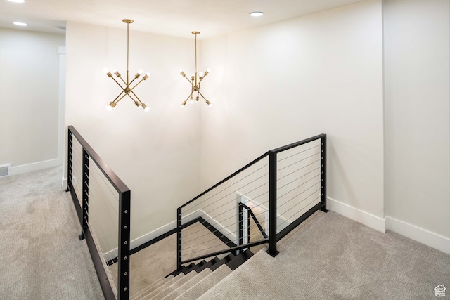 stairs featuring a notable chandelier and carpet flooring