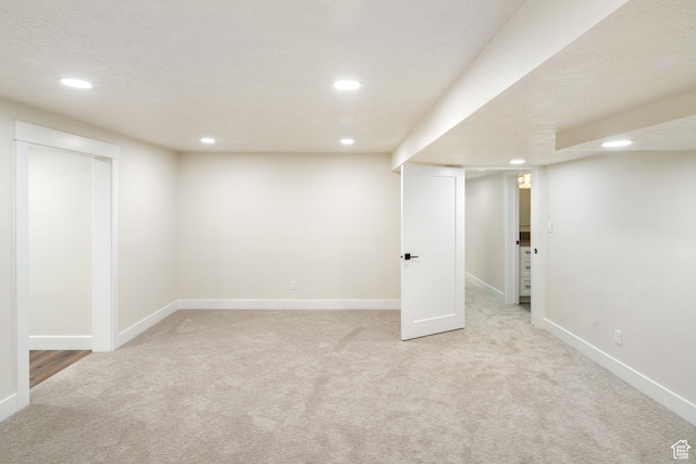 basement with light carpet and a textured ceiling