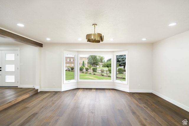 empty room featuring dark hardwood / wood-style floors and a notable chandelier