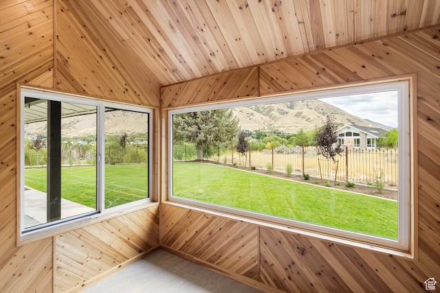 unfurnished sunroom featuring a mountain view, wood ceiling, and vaulted ceiling