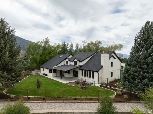 back of property featuring a yard and a mountain view