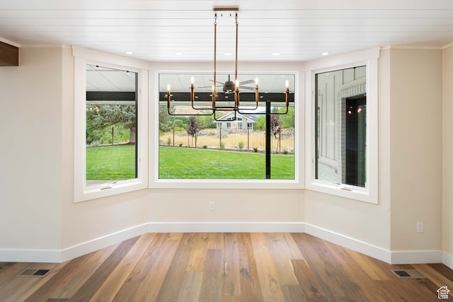 unfurnished dining area featuring wooden ceiling, hardwood / wood-style flooring, a chandelier, and plenty of natural light