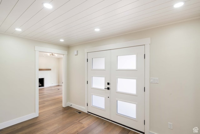 foyer entrance featuring a fireplace, french doors, and hardwood / wood-style flooring
