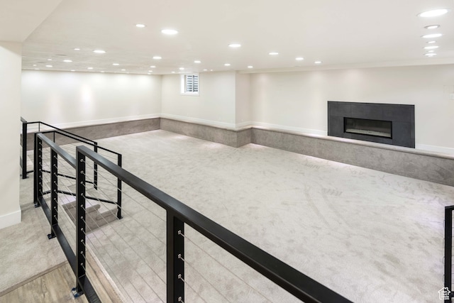 interior space with a tiled fireplace and light colored carpet