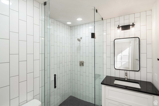 bathroom featuring vanity, toilet, and a shower with shower door
