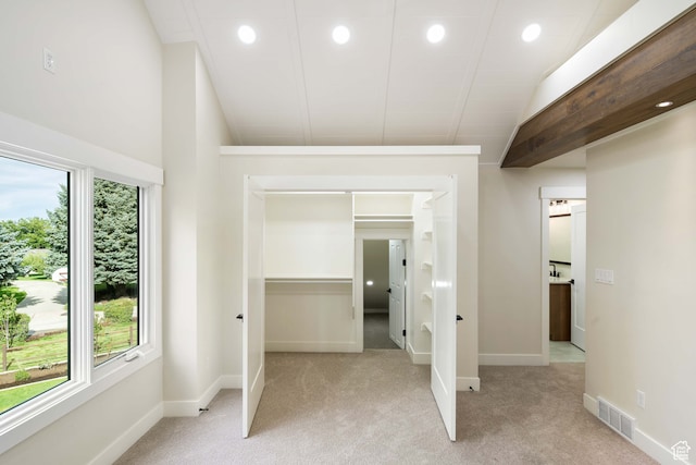 unfurnished bedroom featuring vaulted ceiling and light colored carpet