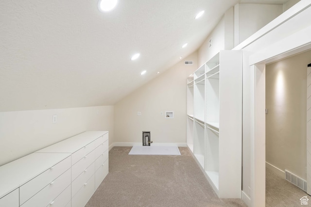 bonus room featuring light carpet, vaulted ceiling, and a textured ceiling