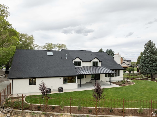 rear view of house with a yard, central AC unit, and a patio area