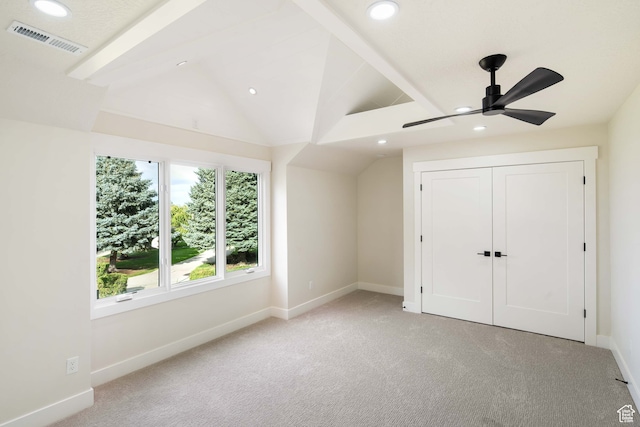 unfurnished bedroom featuring ceiling fan, a closet, lofted ceiling with beams, and light carpet