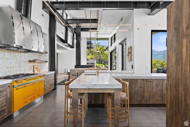 27 Normans Way, Park City, UT 84060 - kitchen featuring concrete floors, stainless steel gas stovetop, backsplash, healthy amount of natural light, and a high ceiling