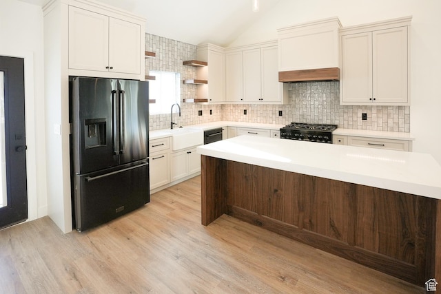 9542 Ridge Pine Rd, Heber City, UT 84032 - kitchen with sink, backsplash, black appliances, vaulted ceiling, and light wood-type flooring