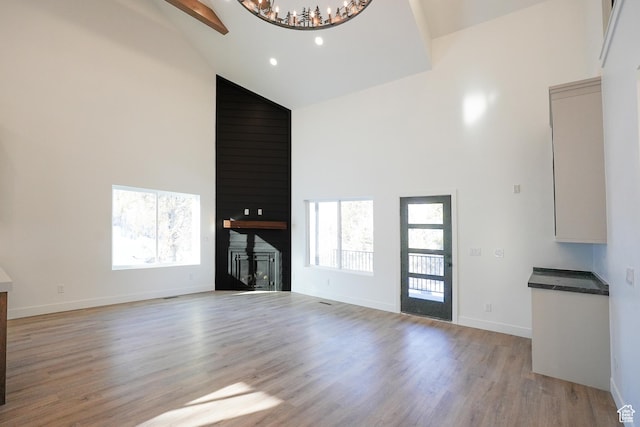 9542 Ridge Pine Rd, Heber City, UT 84032 - unfurnished living room featuring light hardwood / wood-style floors, plenty of natural light, high vaulted ceiling, and a large fireplace