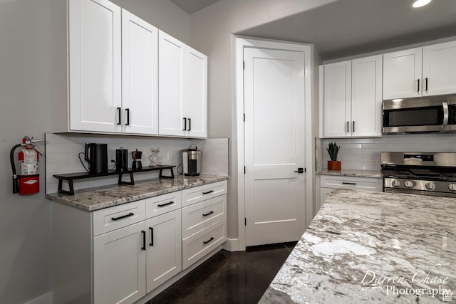 1460 S Windsor Pkwy Unit 5, Hurricane, UT 84737 - kitchen with white cabinetry, stainless steel appliances, backsplash, and light stone counters