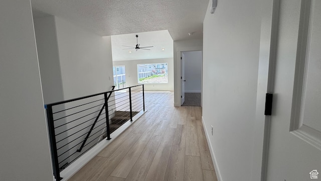 477 W 1860 N Unit 343, Tooele, UT 84074 - hallway with light wood-style flooring, baseboards, a textured ceiling, and an upstairs landing