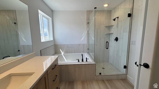 477 W 1860 N Unit 343, Tooele, UT 84074 - full bathroom featuring a shower stall, a garden tub, wood finished floors, vanity, and a textured ceiling