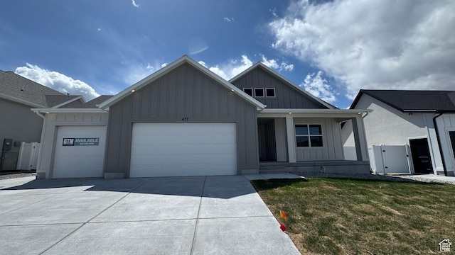 477 W 1860 N Unit 343, Tooele, UT 84074 - view of front facade featuring a front lawn, board and batten siding, an attached garage, driveway, and a porch