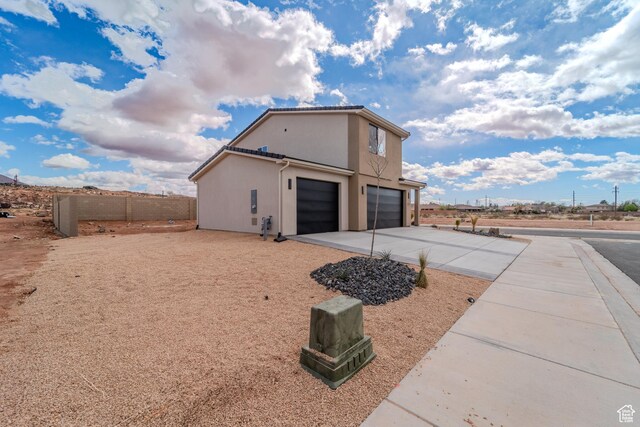 3377 W Palomar, Hurricane, UT 84737 - view of side of home with stucco siding, a garage, concrete driveway, and fence