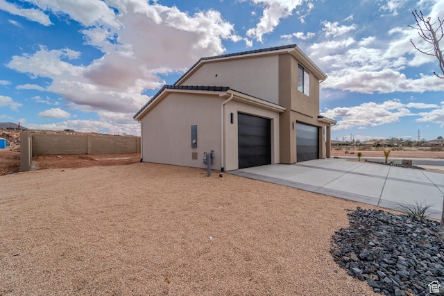 3377 W Palomar, Hurricane, UT 84737 - view of side of home featuring stucco siding, driveway, fence, an attached garage, and a tiled roof