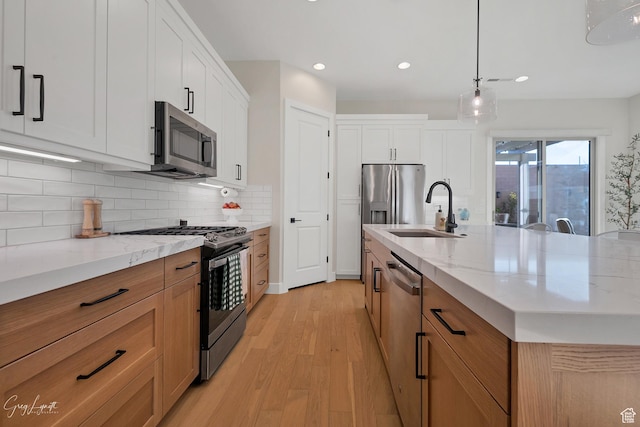 4755 S Purcell Dr, St George, UT 84790 - kitchen with stainless steel appliances, decorative backsplash, a sink, light stone counters, and light wood finished floors