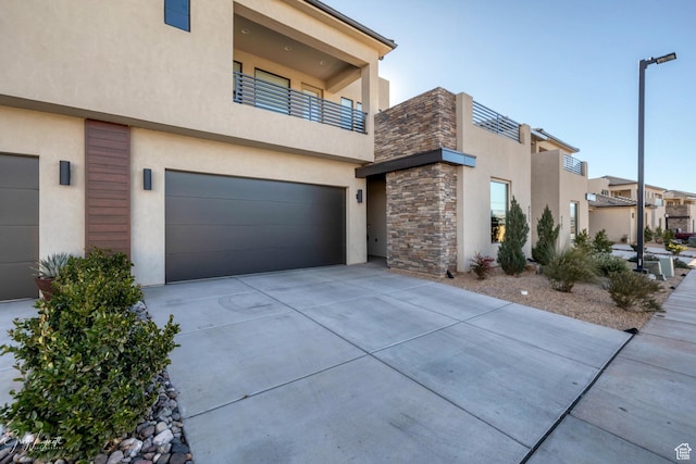 4755 S Purcell Dr, St George, UT 84790 - view of side of home with stone siding, a garage, driveway, and stucco siding
