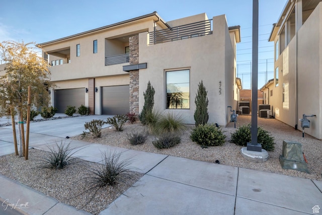 4755 S Purcell Dr, St George, UT 84790 - modern home featuring stone siding, a garage, concrete driveway, stucco siding, and cooling unit