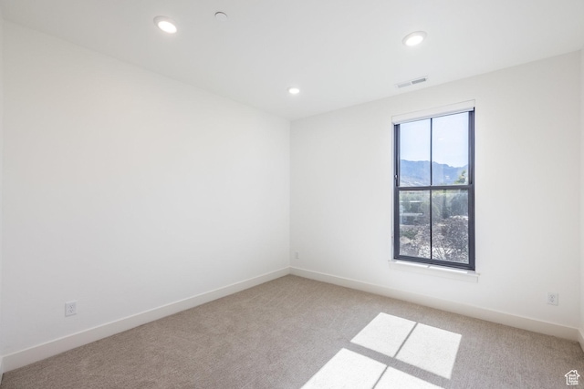 unfurnished room with recessed lighting, baseboards, light carpet, and visible vents