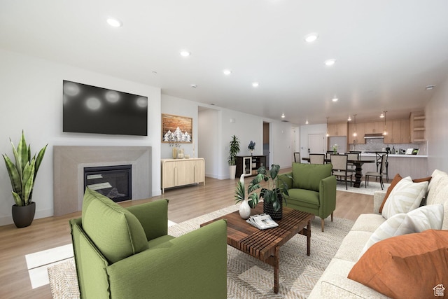 living area featuring recessed lighting, baseboards, light wood-style floors, and a glass covered fireplace