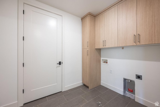 clothes washing area with baseboards, dark tile patterned floors, hookup for a washing machine, cabinet space, and electric dryer hookup