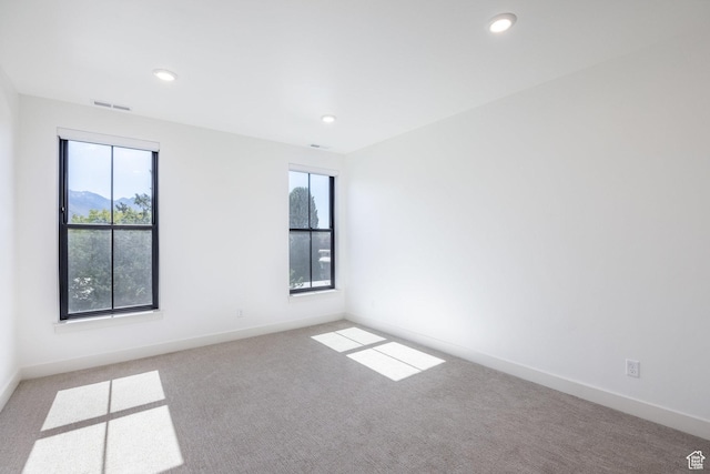 carpeted empty room with recessed lighting, baseboards, and a wealth of natural light