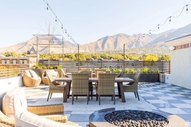 view of patio / terrace with a mountain view, a fire pit, and fence